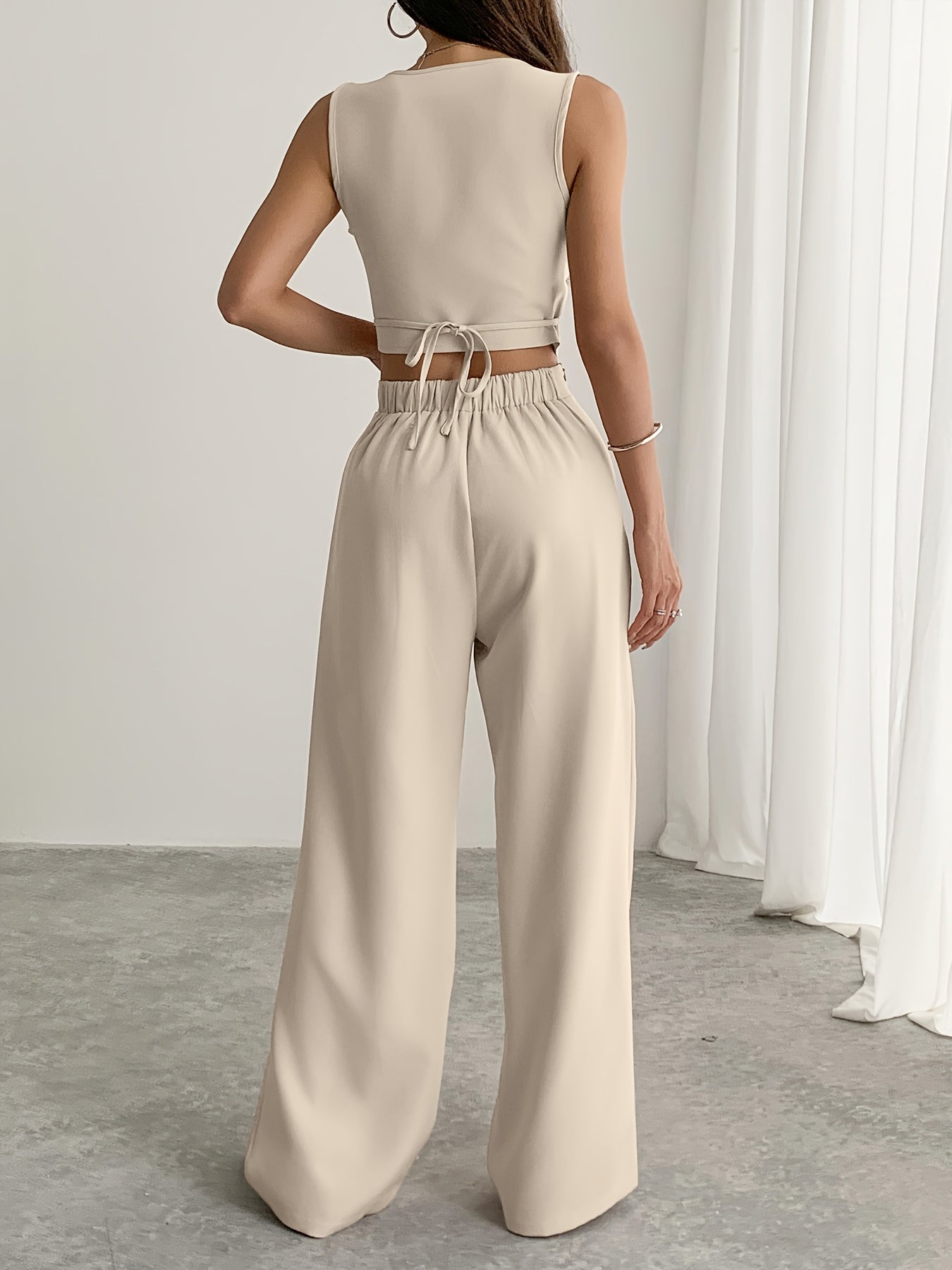 A Set Consisting of Two Women'S Apricot-Colored Sleeveless Cardigans with Square Necklines And Loose-Fitting Wide-Leg Pants.